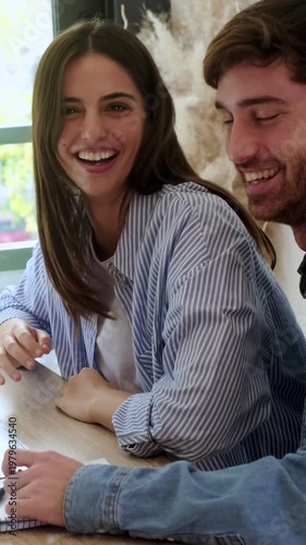 Happy Young Couple Collaborating and Laughing Together at a Bright Modern Office
