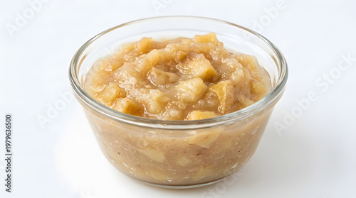 A glass bowl filled with a serving of applesauce on a white background