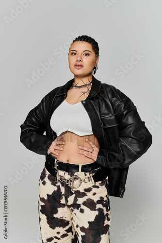 Stylish young woman showcasing urban fashion in a minimalist studio setting