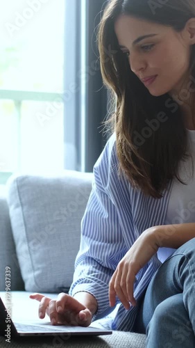 Smiling Young Woman Works Comfortably on Her Laptop at Home