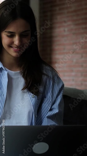 Young Woman Smiling While Working on Laptop in Comfortable Home Environment