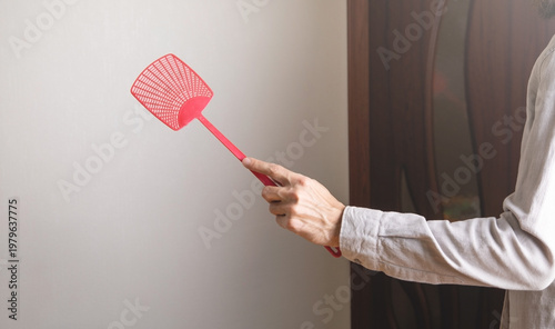 Fotografi Caucasian man holding a fly swatter.