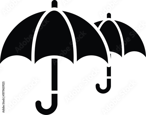 Two black umbrellas standing side by side with white stripes on the canopy