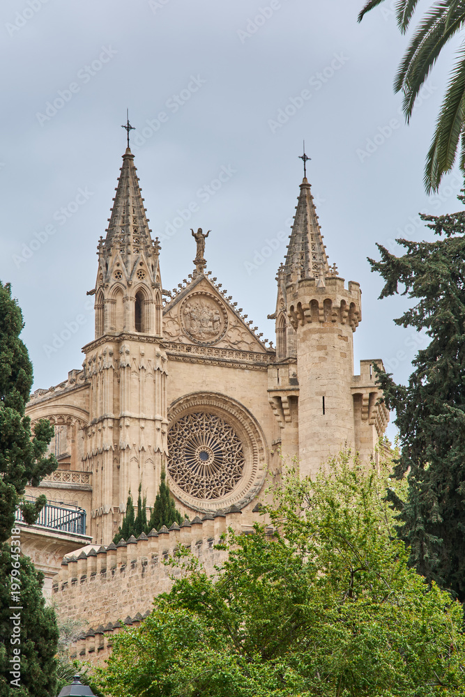 Obraz premium Detailed stone masonry and religious sculptures on the exterior of Palma Cathedral, a premier example of Catalan Gothic architecture in the Balearic Islands.