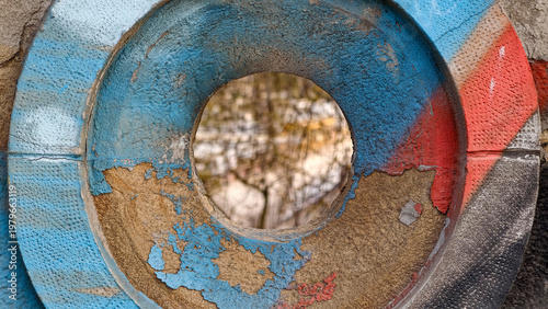 The paint is peeling from the decoration on the old concrete bridge