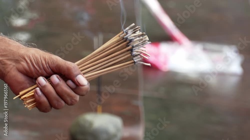 Close up of hand holding dhoopbatti during puja in India, with rising smoke creating a spiritual and calm atmosphere.