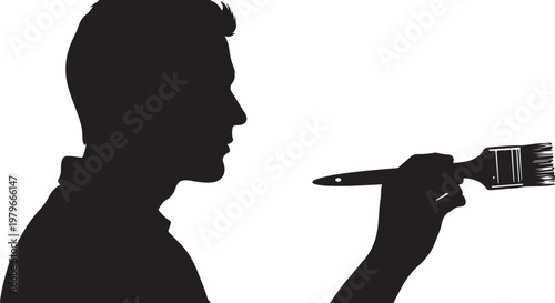 Silhouette of a man holding a paintbrush in hand