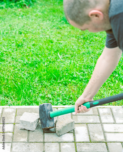 Wallpaper Mural Man hammers brick on paved ground Torontodigital.ca