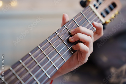 Photography Learning to play chords on a guitar in a cozy setting