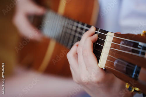 Φωτογραφία Close view of a person playing guitar indoors in a casual setting