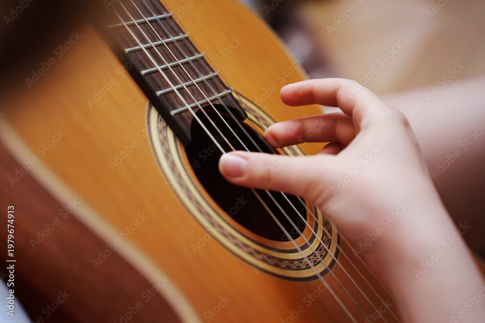 Fototapeta premium Close-up of hand playing guitar strings in a calm setting