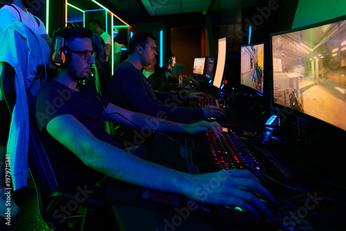 Konstfotografi Competitive Gamers Playing Multiplayer Shooter on PCs in Neon-Lit Gaming Arena W
