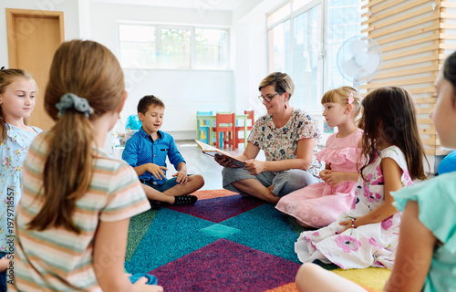 Preschool teacher reading aloud to a group of children during circle time on a colorful rug