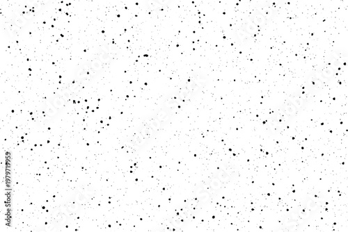 Scattered black ink marks create a speckled grunge texture on a crisp white surface