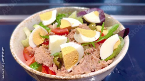 close up of salad bowl containing lettuce boiled eggs tuna tomatoes and lettuce