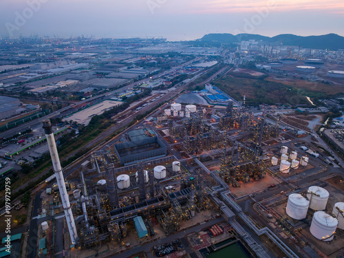 Industrial Petrochemical Refinery Complex Illuminated At Twilight Near Coastal Logistics Infrastructure