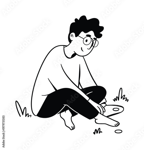 A person in glasses sitting on the grass, playing with a frisbee