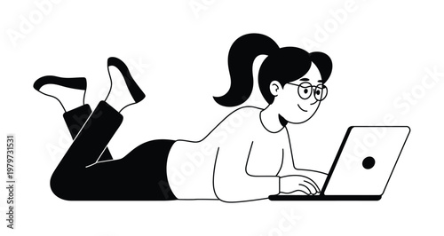 A woman with glasses and a ponytail lying on her stomach, typing on a laptop