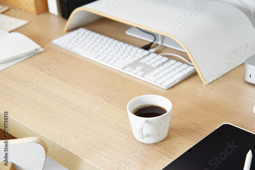 Minimal home office desk with coffee cup tablet and keyboard