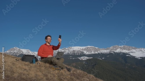 Frustrated digital nomad searching for mobile phone signal on remote Carpathian mountain hill static tripod hero shot 4K