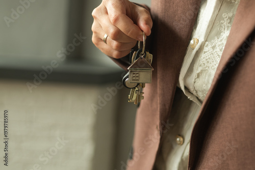 Woman holding keys to house. Moving, renting or buying an apartment.