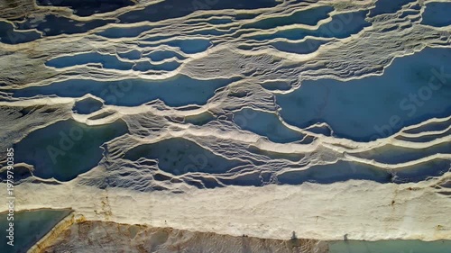 Serene turquoise pools cascade over white terraces. Sunlight glints softly on mineral-rich water surfaces. Natural beauty evokes calm and wonder. Ideal for travel, wellness, or nature-focused visuals