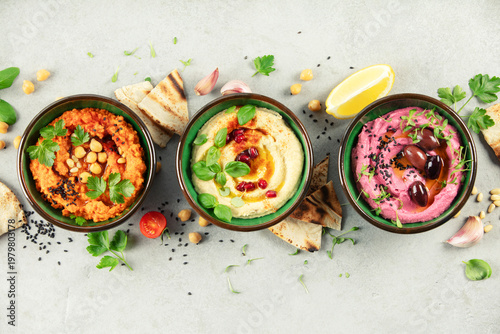 Obraz na płótnie Colorful Hummus Trio with Garnishes and Pita Bread