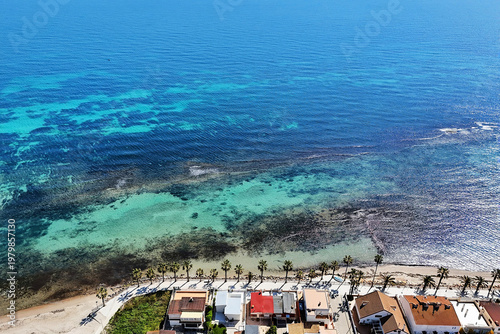 Aerial view of coastal resort town of Torre de la Horadada, seafront promenade, Mediterranean Sea, beach and residential buildings. Costa Blanca, Alicante province, Spain