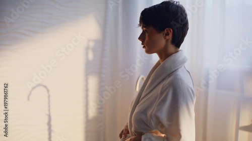 Woman removing terry robe revealing back closeup. Slim brunette lady spa session