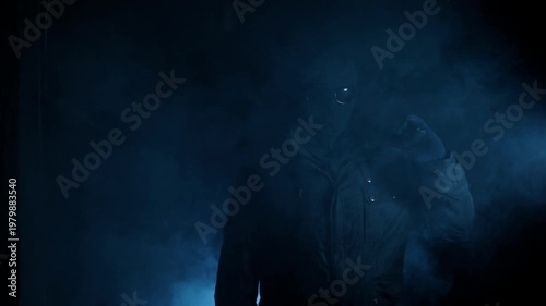 Mysterious Hooded Figure Standing and holding gun on his shoulder in Smoke with Blue Light, Anonymous Concept