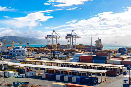 Wellington, New Zealand - 18 February 2026: View of the bustling port where stacks of colorful shipping containers meet the vast expanse of the turquoise sea.