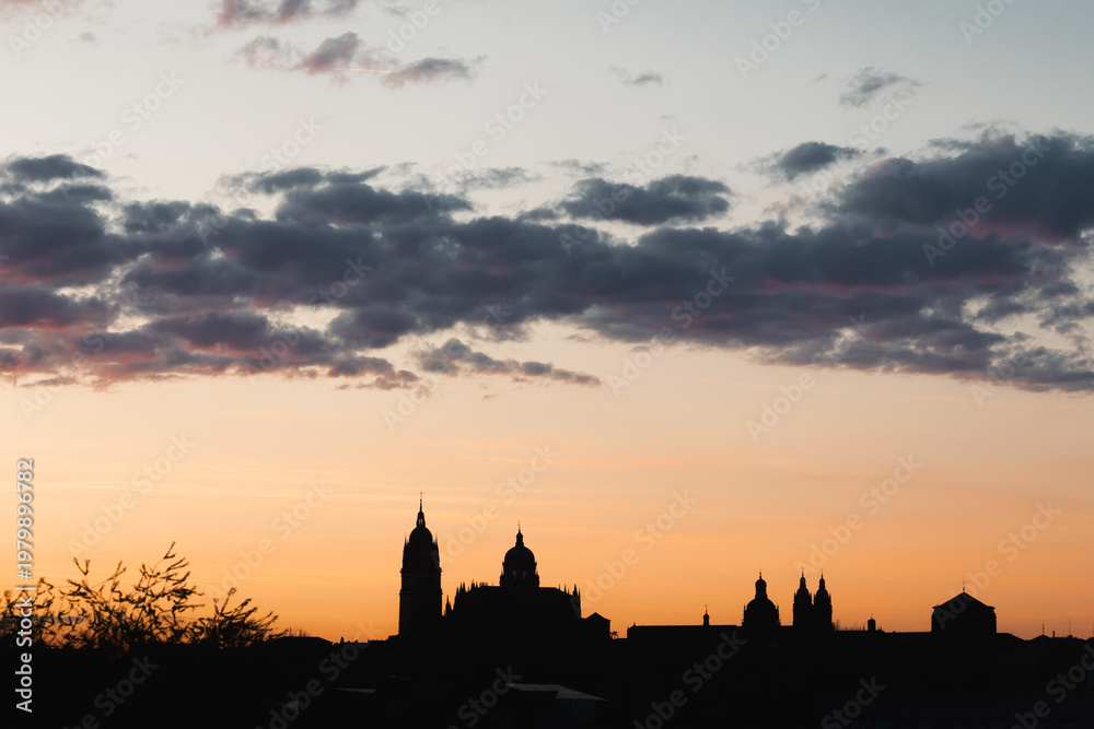 Fototapeta premium Salamanca cathedral skyline silhouetted against a colorful sunset sky, viewing the historic Spanish city architecture during golden hour and twilight evening scene