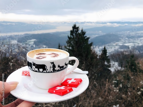 Cuadro en lienzo Cup of coffee with Swiss chocolates overlooking mountain landscape