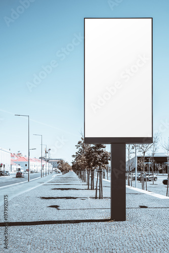 Large blank billboard or LED/LCD screen mockup on sunny urban sidewalk, vertical outdoor advertising template with copy space, modern street perspective, clear sky and clean city background