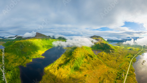 Aerial drone view of misty mountains and fjords in Lofoten, Norway. Atmospheric arctic landscape with fog, moody clouds and scenic northern nature.