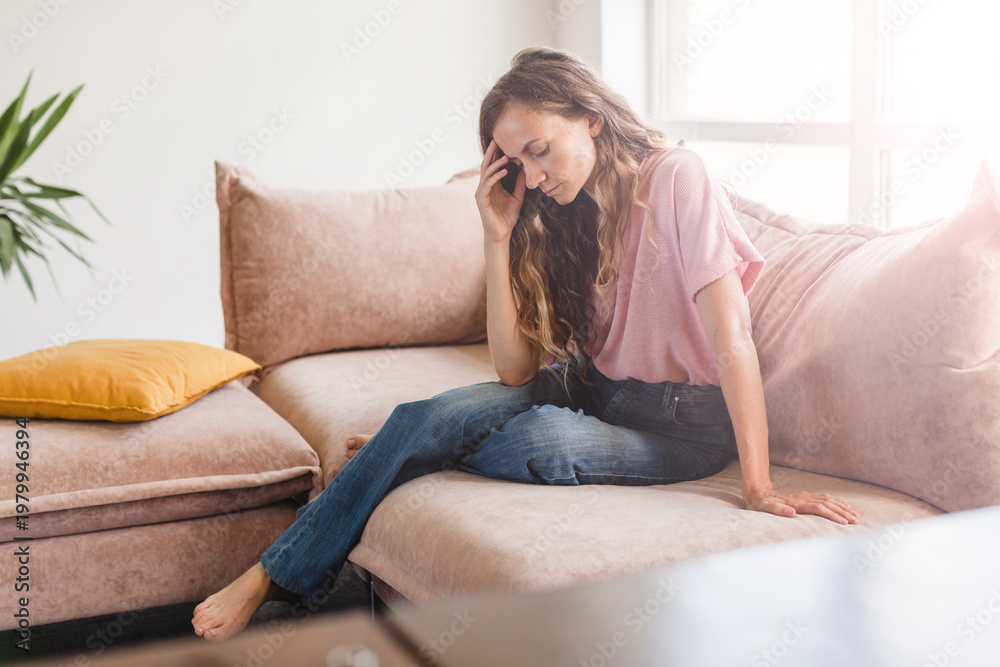 Fototapeta premium Sad woman thinking about problem, sitting alone on couch