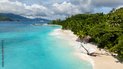 Green hills extending to the turquoise ocean, with lush vegetation and blue skies. Therese. Seychelles, Mahe.