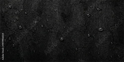 A dark grunge background of rain drops on a textured grey window surface with a rough stone pattern and macro macro concrete material