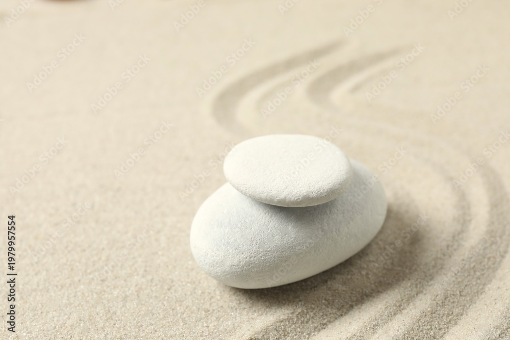 Obraz premium White stones on the sand with patterns. Zen concept. Zen stone garden