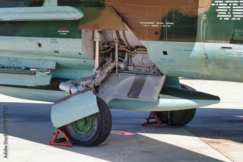 Foto Aircraft under maintenance at an airbase with gear assembly and painted camoufla