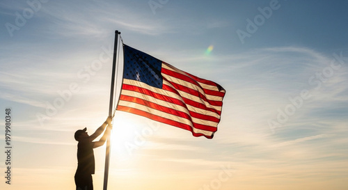 Silhouette of a person raising the american flag against a clear sky at sunset