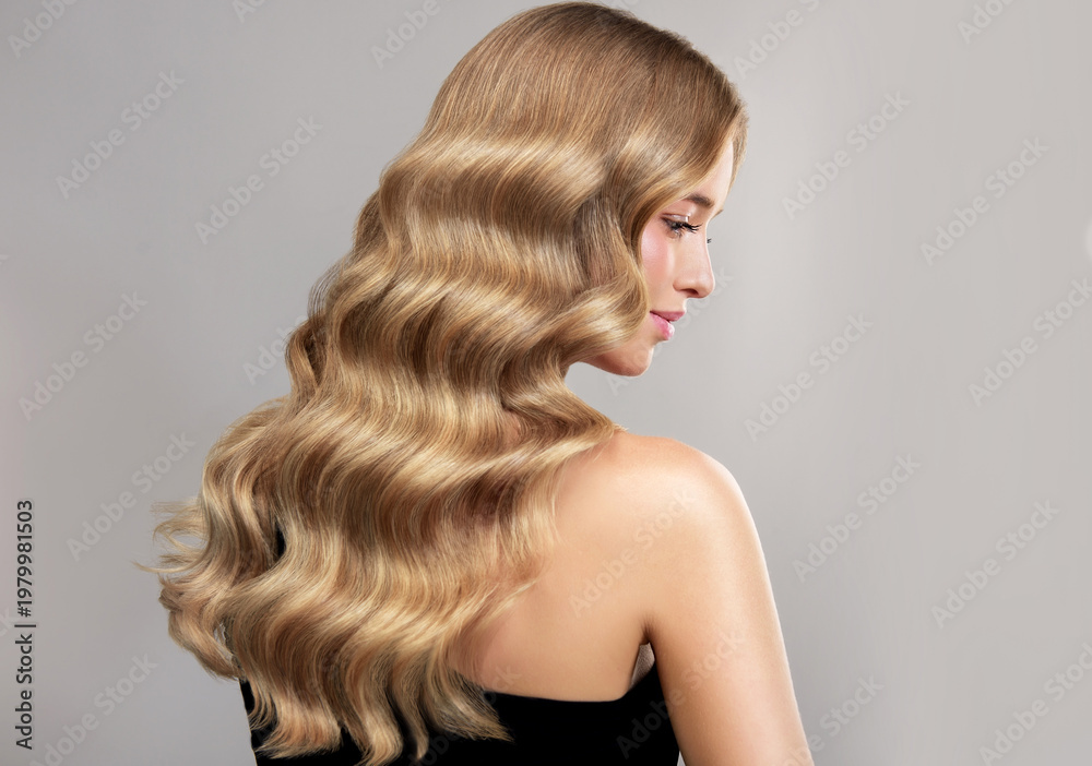 Naklejka premium Beauty blonde girl with long and shiny wavy Hair ,coloring and toning, shatush , air touch and balayash . Beautiful woman model with curly hairstyle . Beauty salon and barbershop . Hair curling 