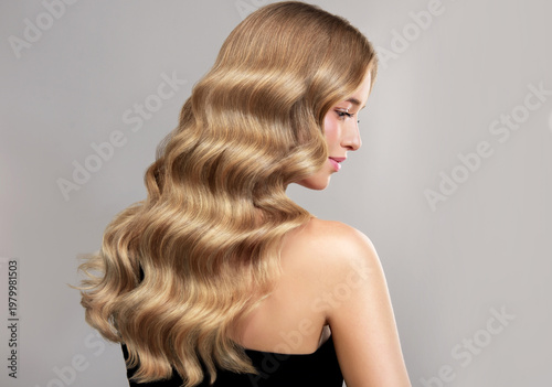 Beauty blonde girl with long and shiny wavy Hair ,coloring and toning, shatush , air touch and balayash . Beautiful woman model with curly hairstyle . Beauty salon and barbershop . Hair curling 
