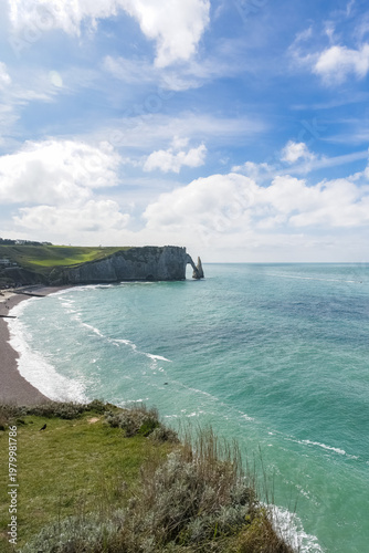 Etretat in Normandy, the famous cliffs and needle on the pebble beach
