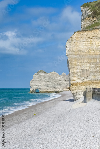 Etretat in Normandy, the famous cliffs and needle on the pebble beach
