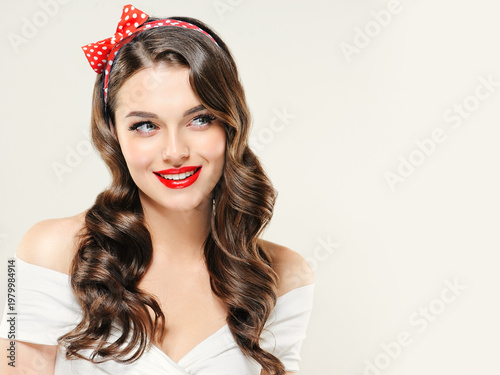 A Pin Up smiling young woman in a retro outfit  showcasing an invisible Presenting your product .Beautiful smile vintage girl with curly hair  .Expressive facial expressions. wavy hairstyle