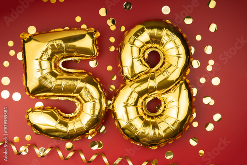58th birthday celebration. Gold festive balloons number 58 year anniversary on red background with confetti. Birthday or wedding event.
