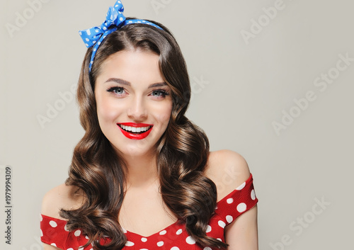 A Pin Up smiling young woman in a retro outfit  showcasing an invisible Presenting your product .Beautiful smile vintage girl with curly hair  .Expressive facial expressions. wavy hairstyle