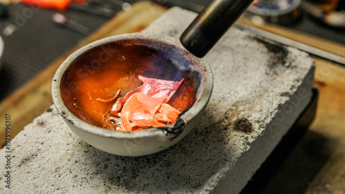 Photos Artisan melting copper in a crucible with a propane torch
