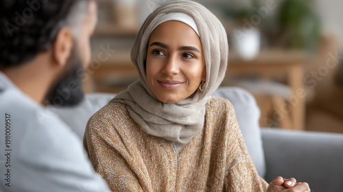 Muslim woman supporting a new group therapy participant to speak during a meeting at a mental health center, inclusive mental health support concept, community care, with copy